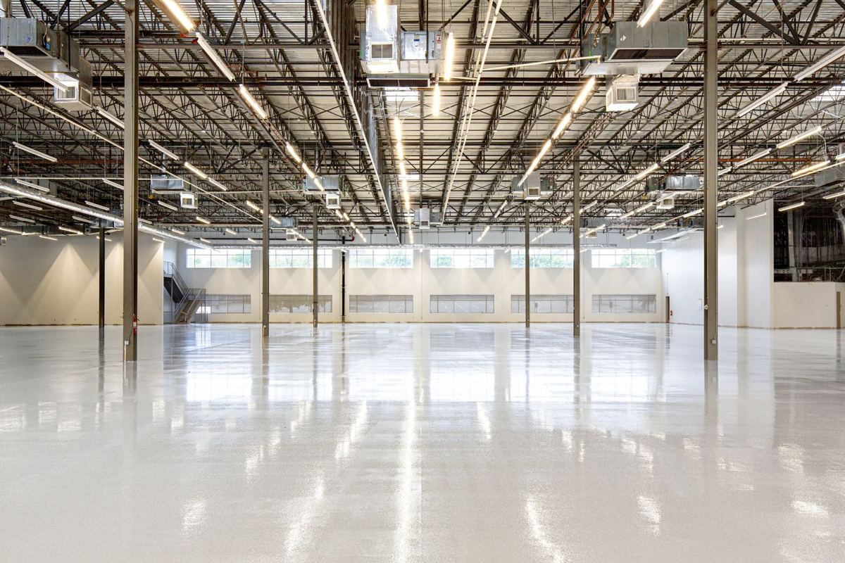 Large glossy warehouse floor reflecting the ceiling lights